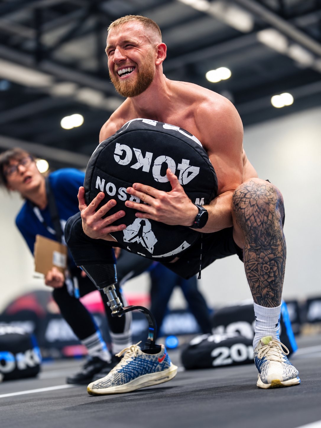 Craig Walton, amputee personal trainer, lifting a 40kg sandbag